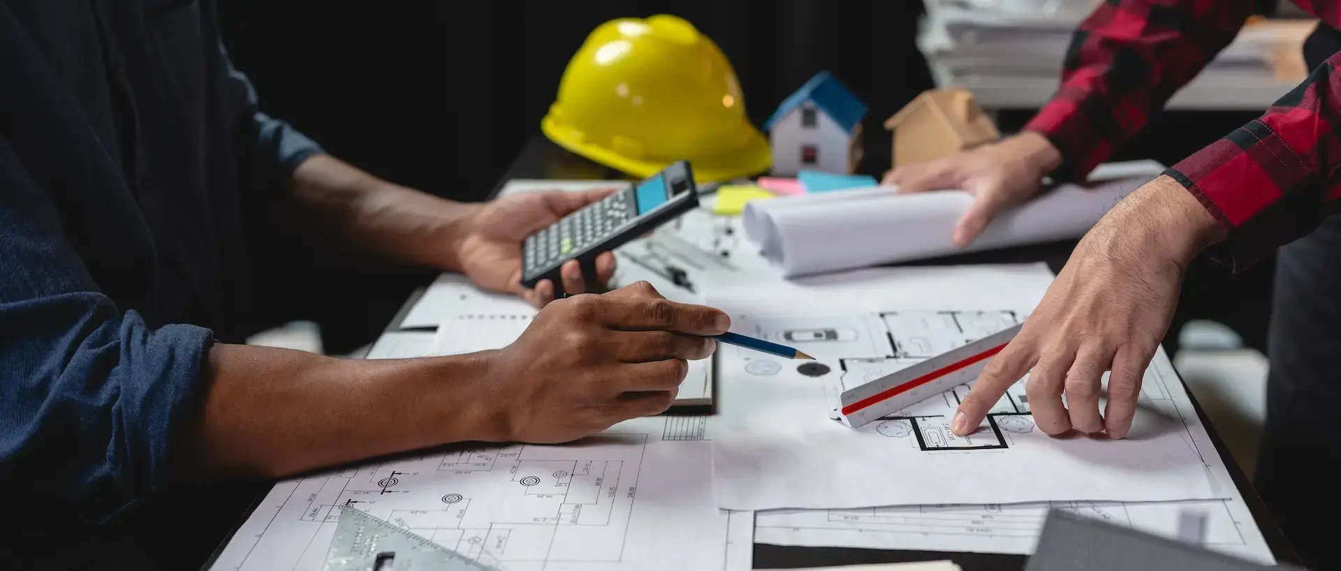 Team of engineers reviewing blueprints sketch of a construction build