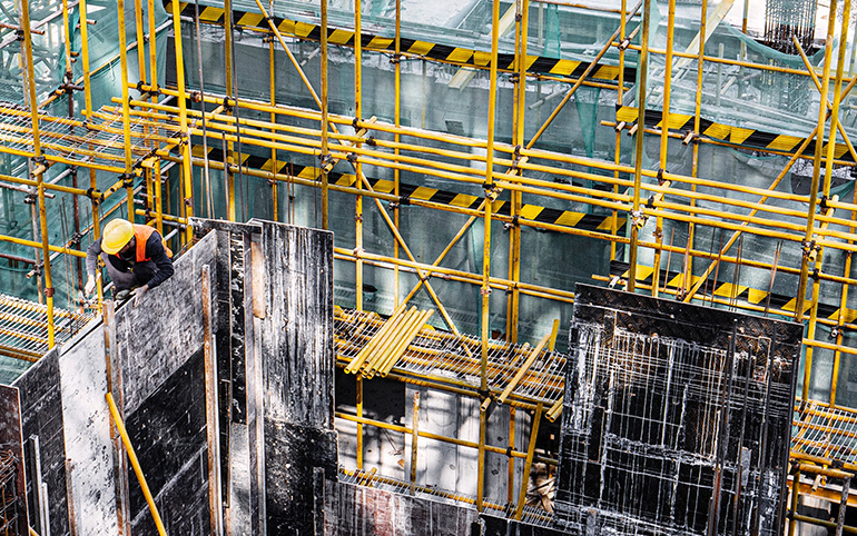 a construction site with a man in a helmet and yellow vest